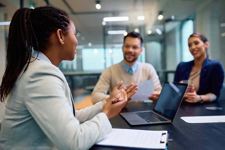 Figura professionale femminile che svolge una formazione a due suoi colleghi