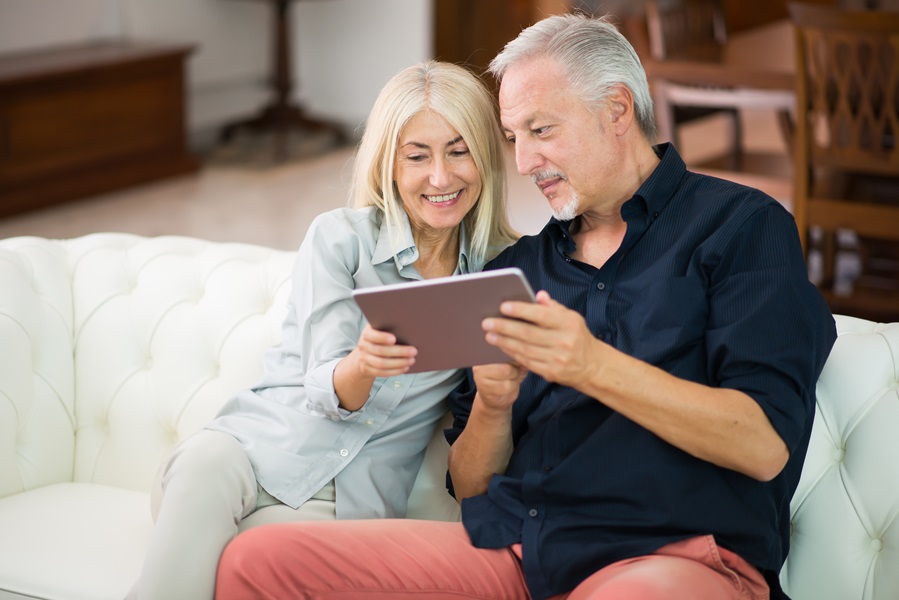 Coppia di uomini adulti sul divano che usano un tablet