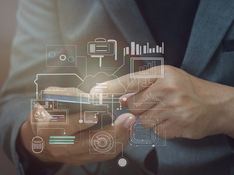 Icone di elementi informatici davanti a un uomo che usa uno smartphone