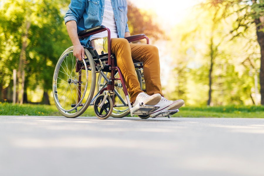 Giovane ragazzo in sedia a rotelle in un parco