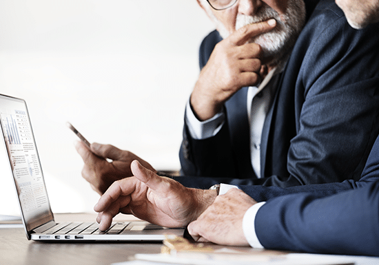 Due persone che si confrontano davanti ad un pc, grafici sullo schermo