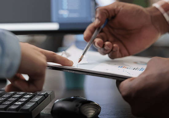 Due persone che consultano un documento contenente grafici e statistiche