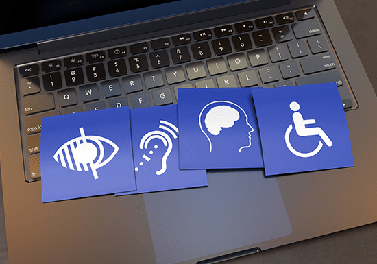 Icone di disabilità appoggiate su un pc portatile